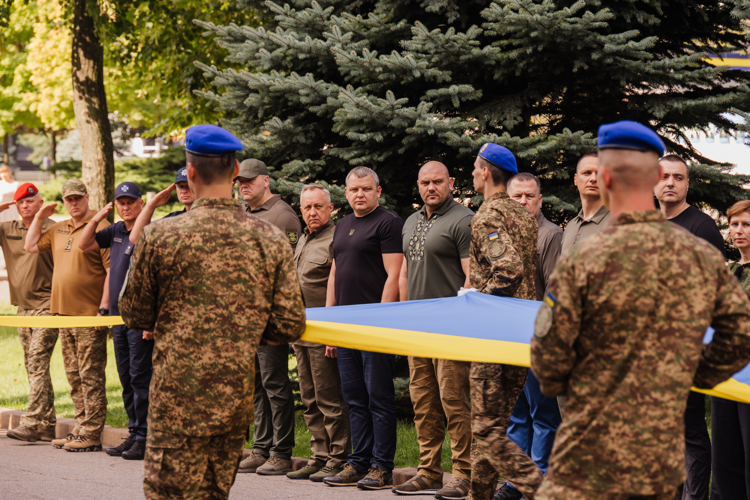 Учасники церемонії вшановують український стяг
