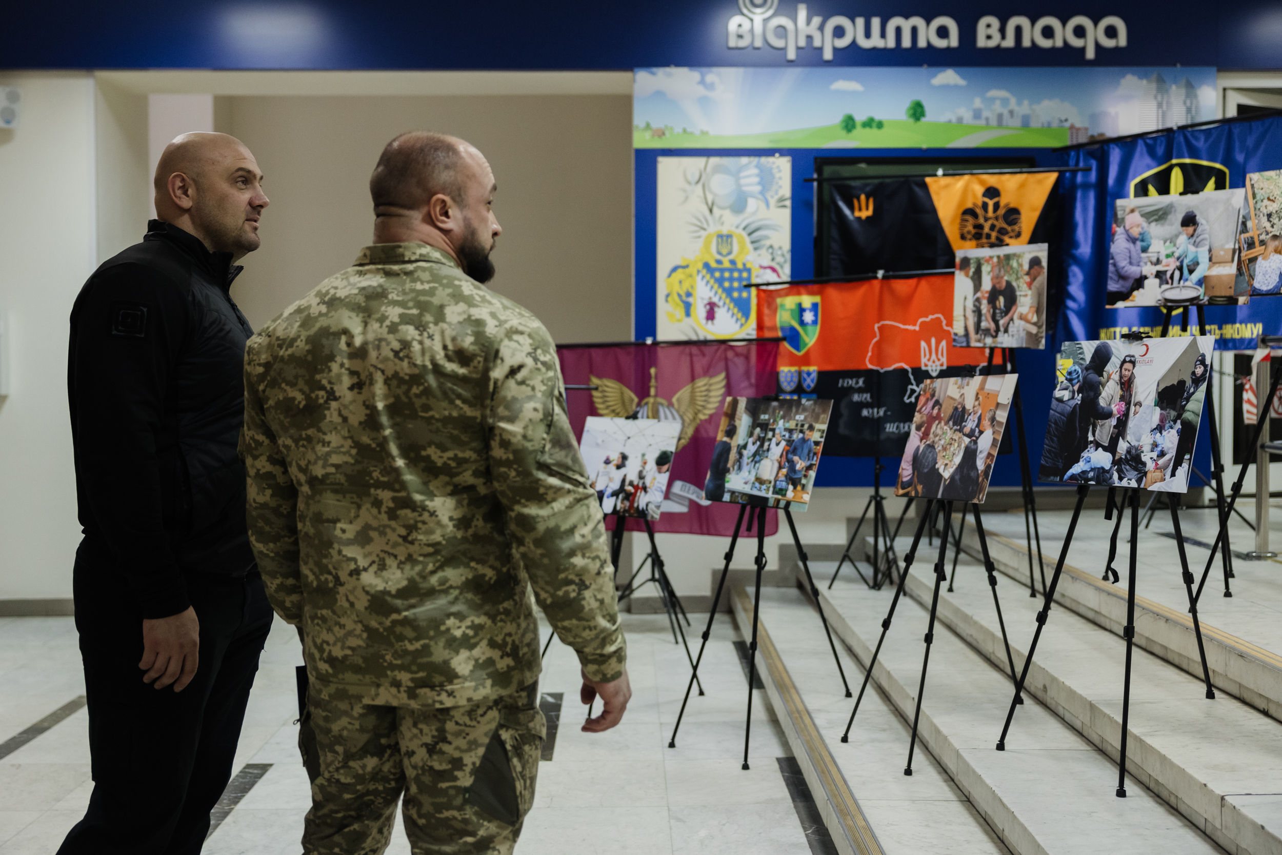 Сергій Лисак переглядає фотовиставку до Міжнародного дня волонтера 