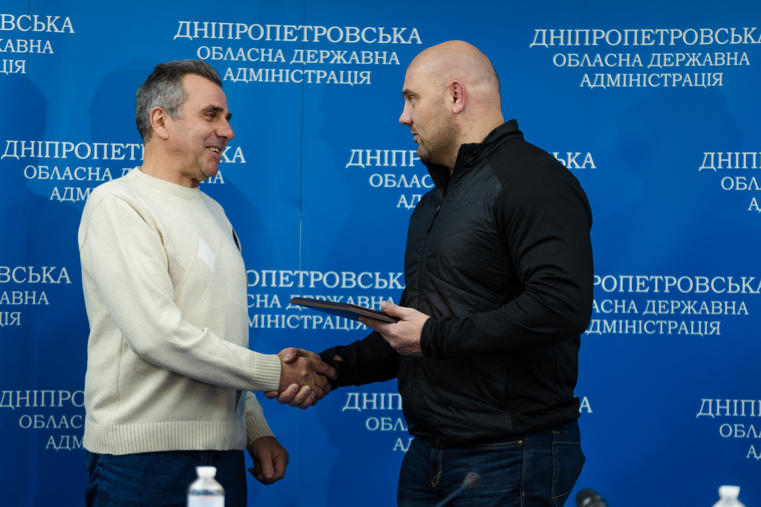 Сергій Лисак тисне руку енергетику, вручаючи йому нагороду