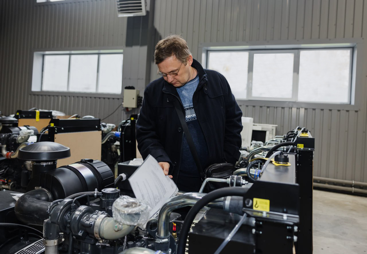 Учасник зустрічі оглядає двигуни, які використовують у виробництві генераторів