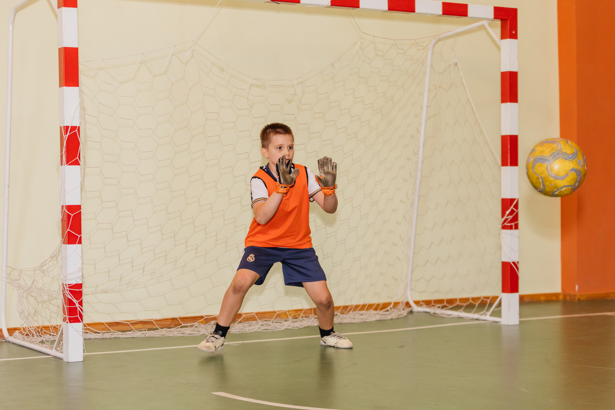 Юний голкіпер на воротях ловить м’яч