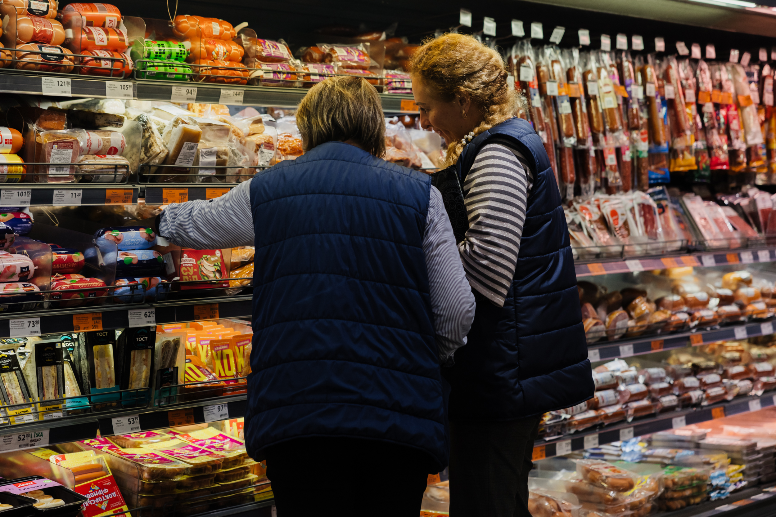 Працівниці торговельної мережі біля продуктових вітрин
