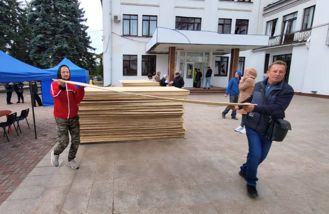 Люди несуть будівельні матеріали