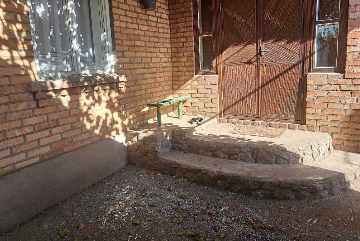 Скло від вибитих шибок перед ґанком приватного будинку 