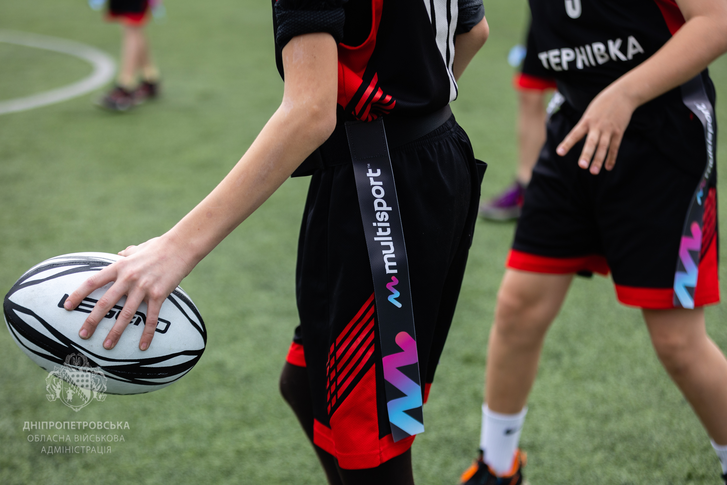 Хлопець тримає міцно регбійний м’яч 