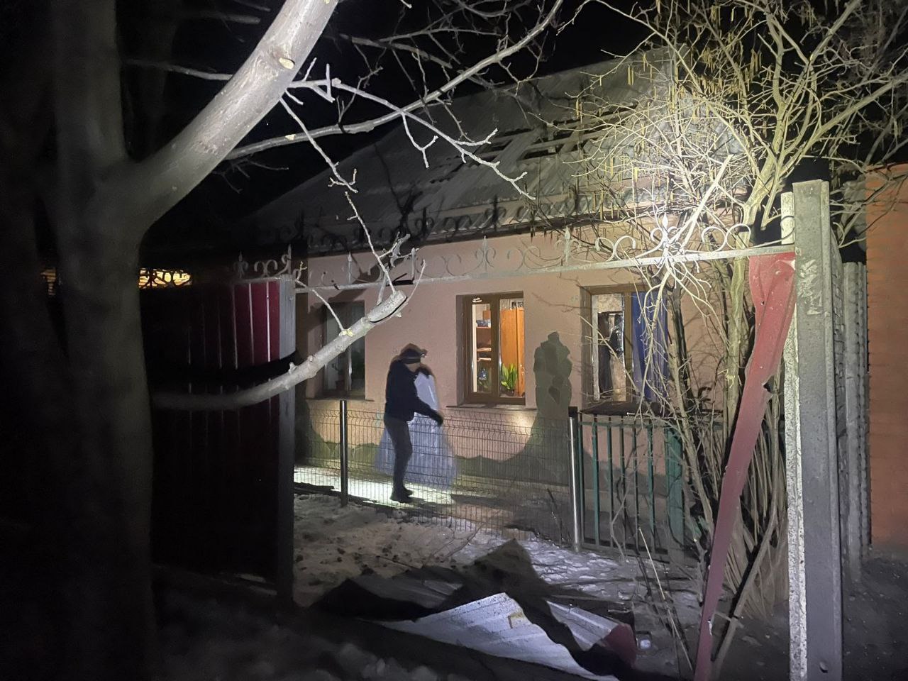 Місцевий мешканець затуляє вибите вікно у приватному будинку