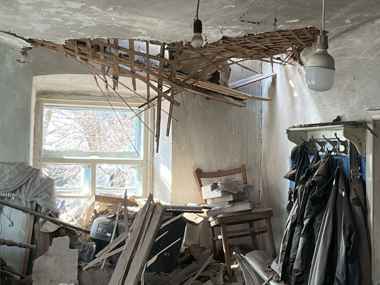У кімнаті проломлена стеля та розбите вікно, все в уламках