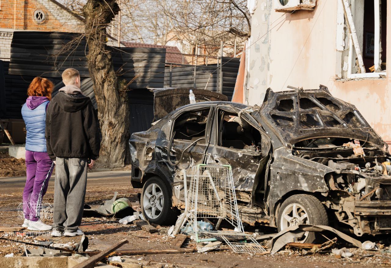 Люди оглядають практично знищену через атаку автівк