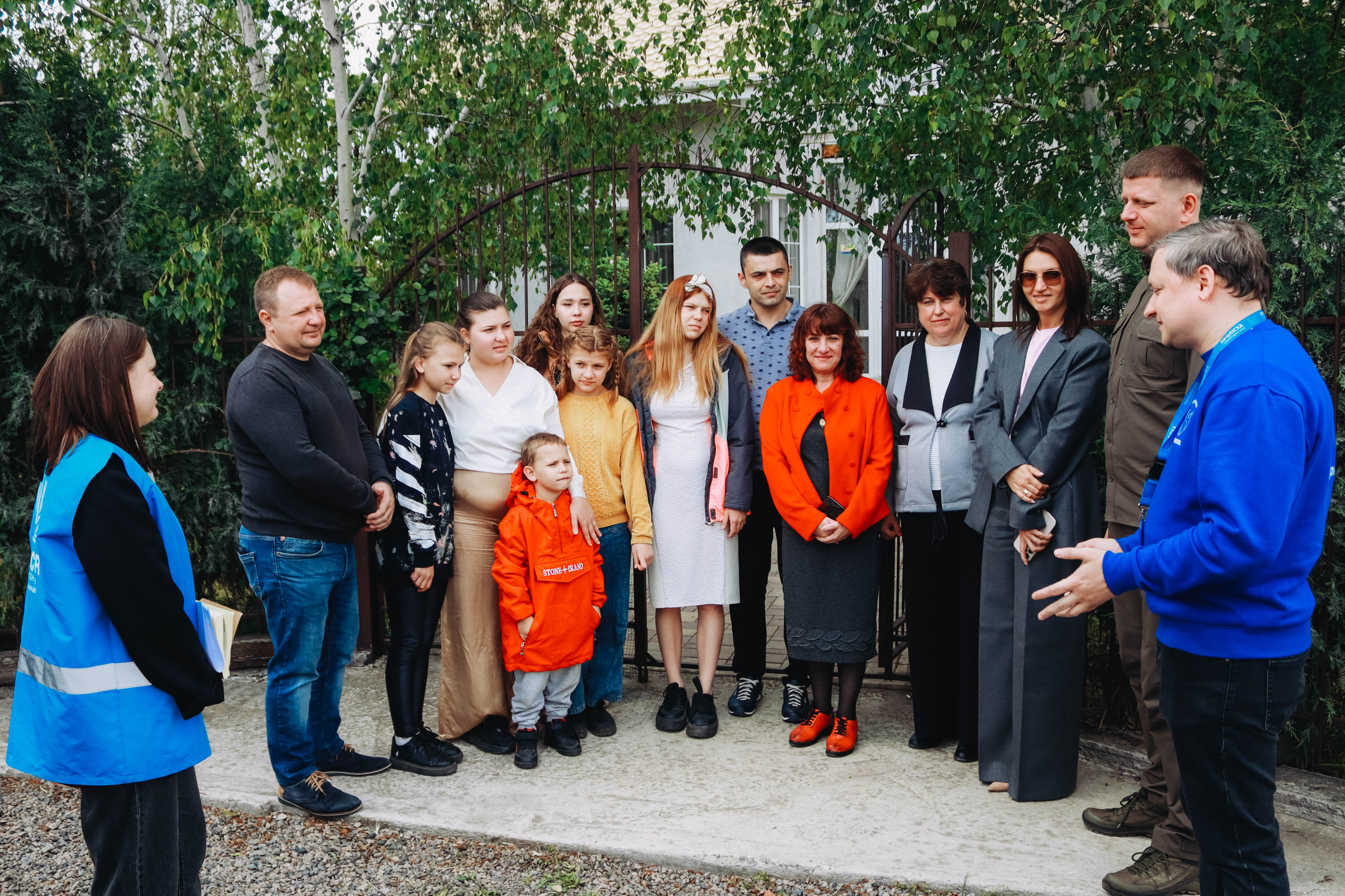 Фото великої родини Лі та представників влади, УВКБ ООН та гуманітарної місії «Проліска»
