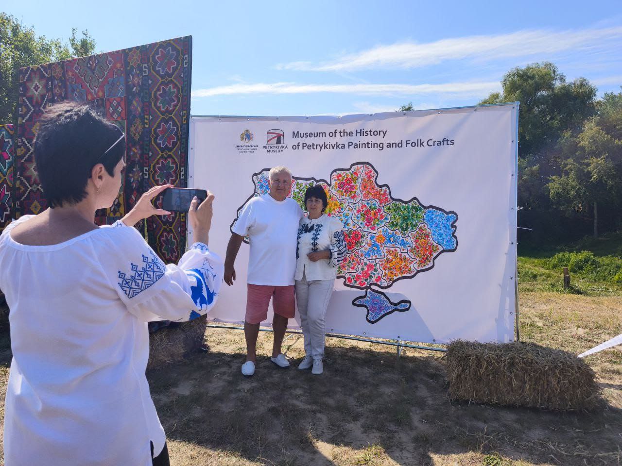 Відвідувачі фесту фотографуються на фоні карти України, де кожен з регіонів розмальований різними орнаментам Петриківського розпису